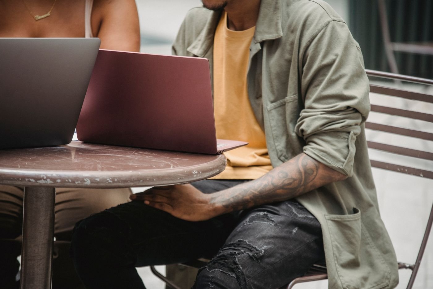 Two freelancers working together at an outdoor cafe.